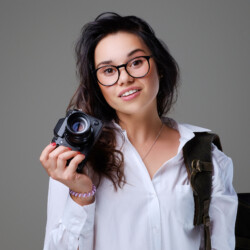 positive-female-tourist-with-photo-camera-travel-backpack